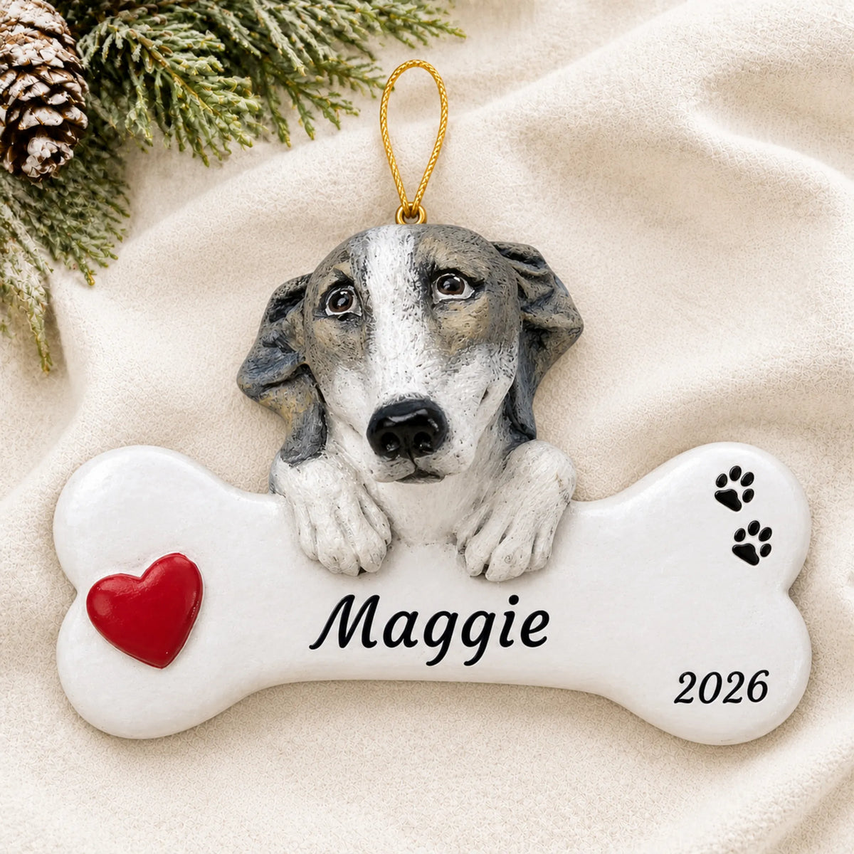Personalized Greyhound Dog Bone christmas ornament laid on a soft white knit blanket