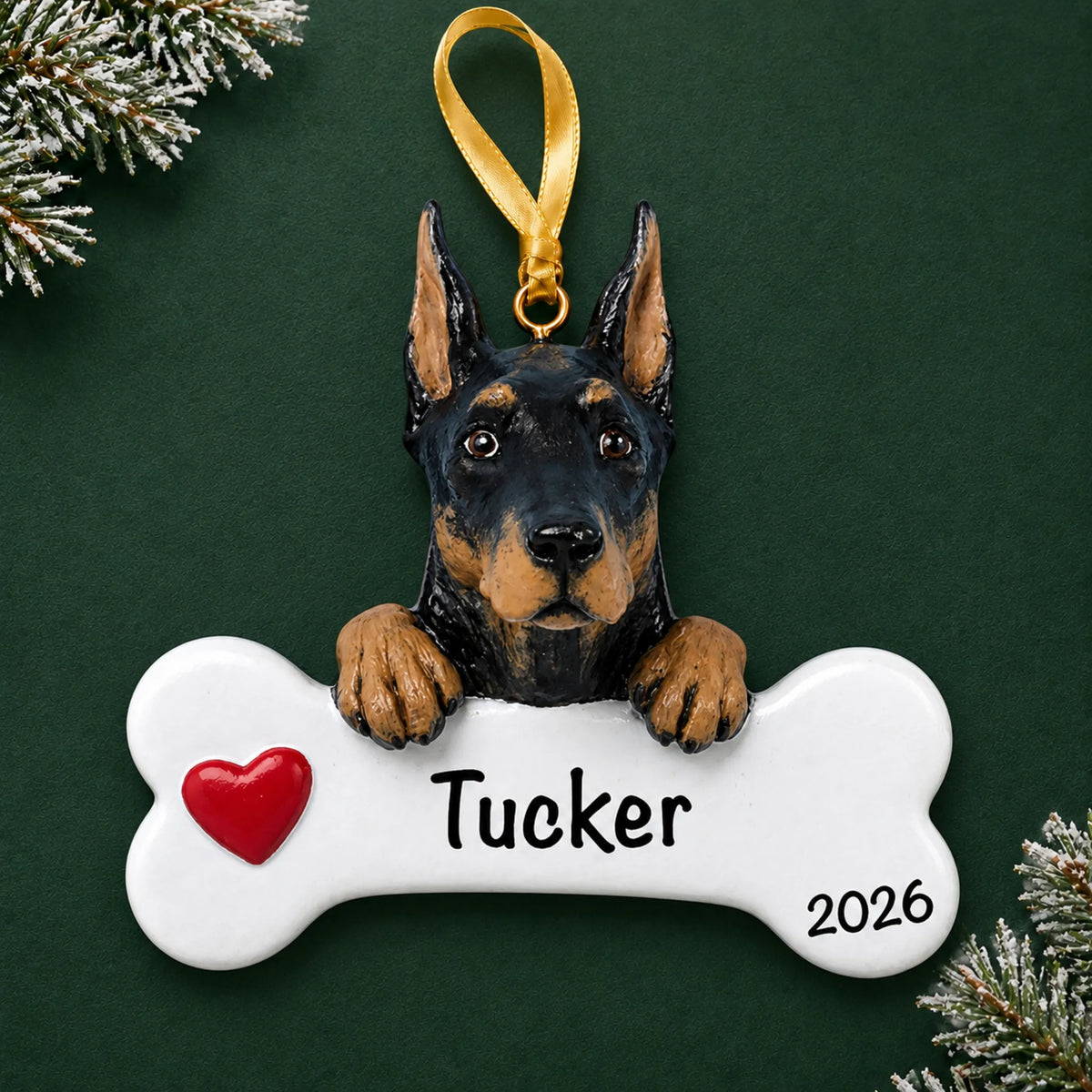 Personalized Doberman pinscher dog bone Christmas ornament, engraved with a name and year, on a green holiday backdrop