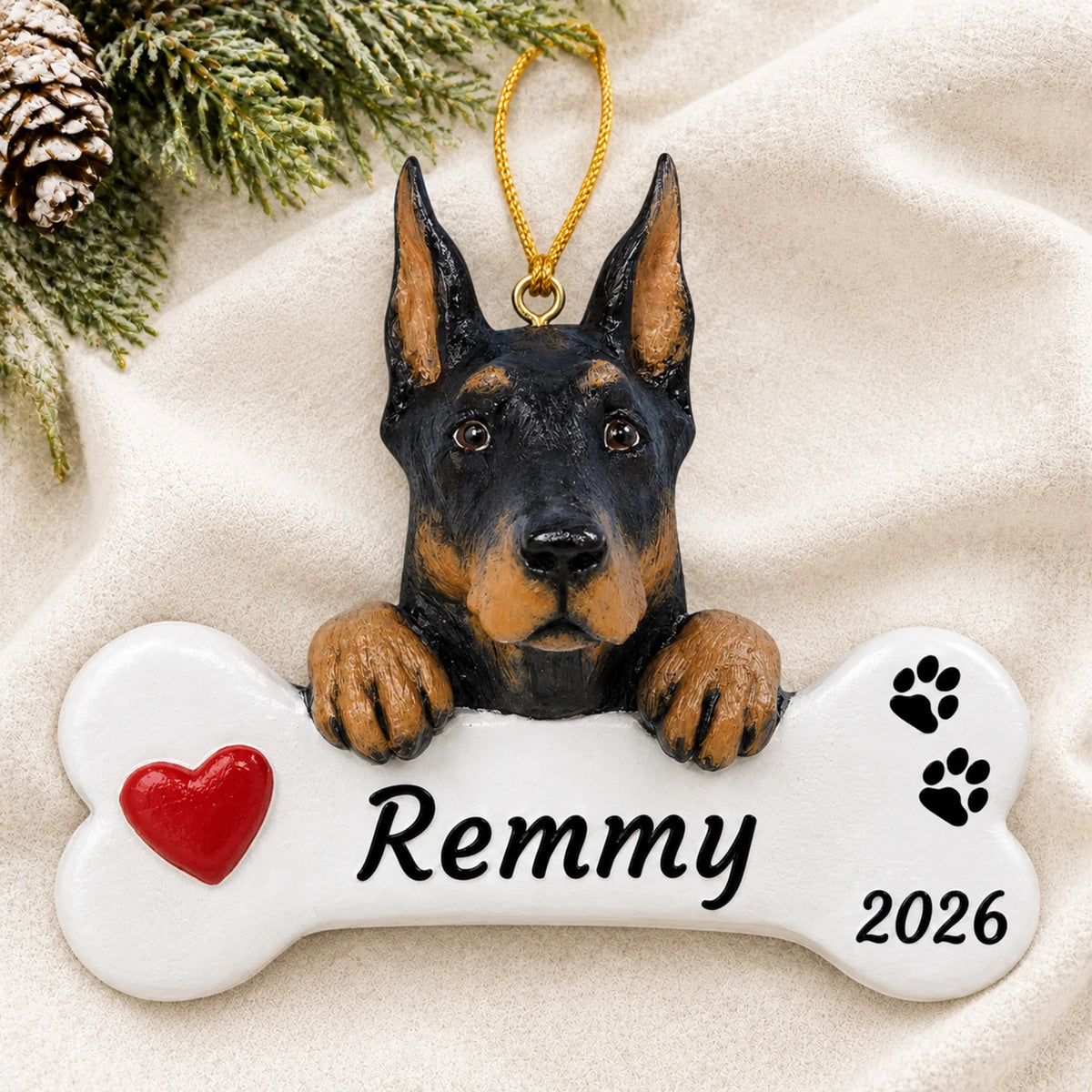 Personalized Doberman Pinscher Dog Bone christmas ornament laid on a soft white knit blanket