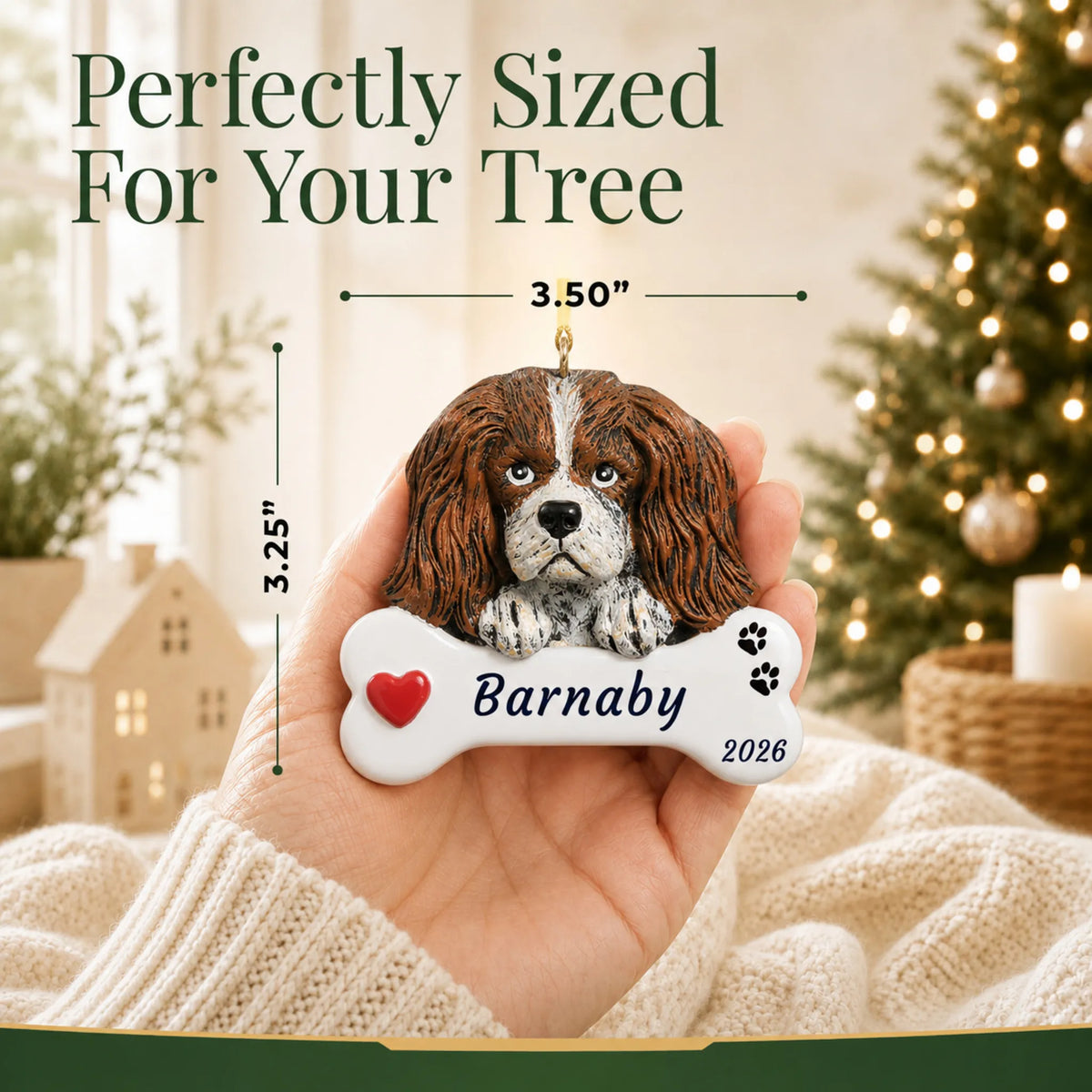 Size guide: the personalized King Charles Cavalier Dog Bone christmas ornament is 3.50 in wide by 3.25 in tall, shown in hand