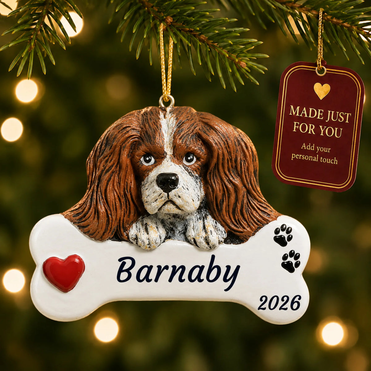 King Charles Cavalier Dog Bone christmas ornament hanging on a lit Christmas tree with a Made Just For You gift tag