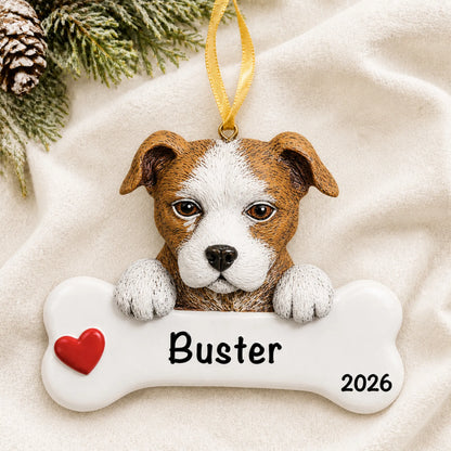 Personalized Staffordshire pit bull dog bone Christmas ornament resting on a soft white blanket with pine and pinecones
