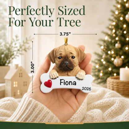 Hand holding the personalized puggle Christmas ornament to show its 3.75 inch width