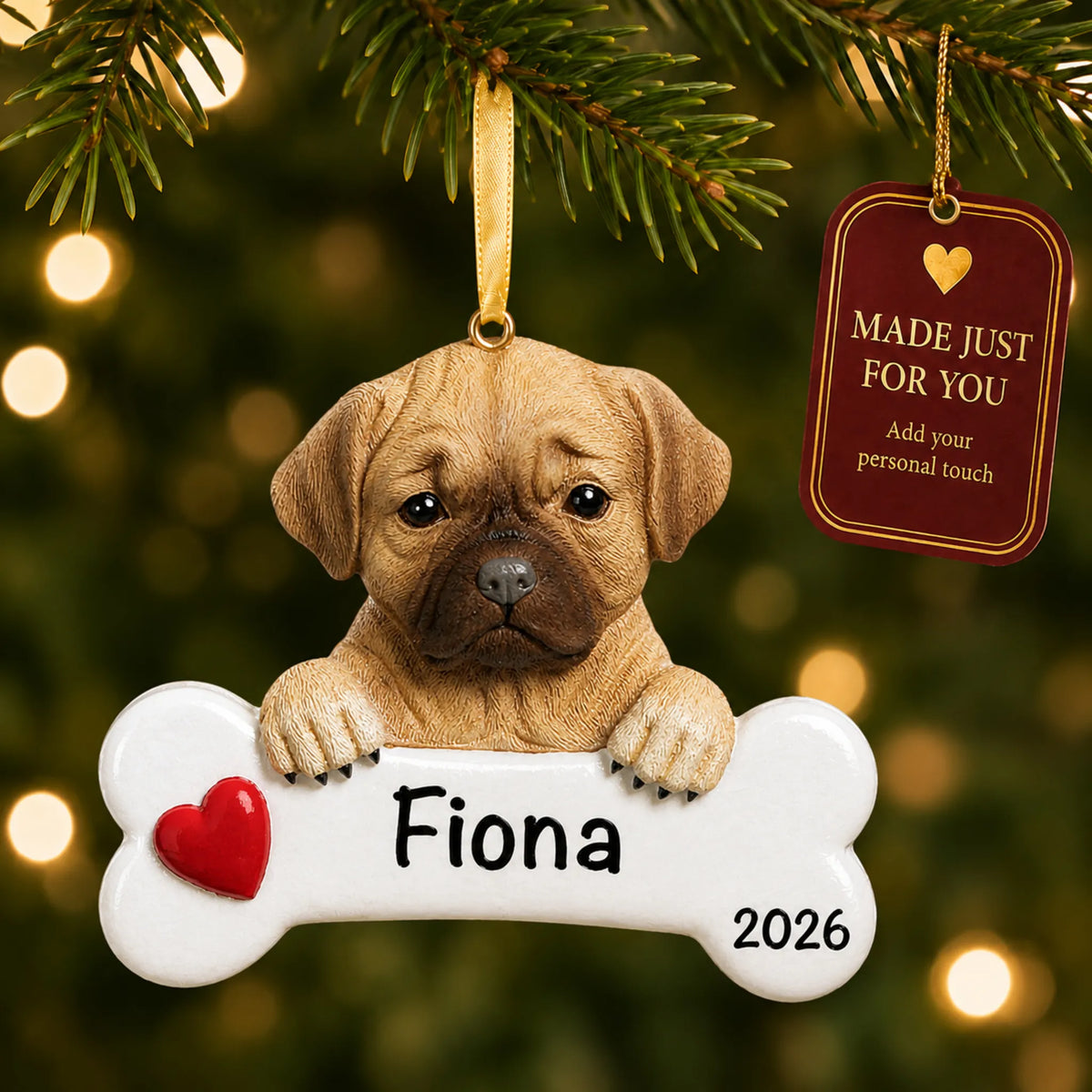 Personalized puggle Christmas ornament hanging on a lit tree beside a Made Just For You tag