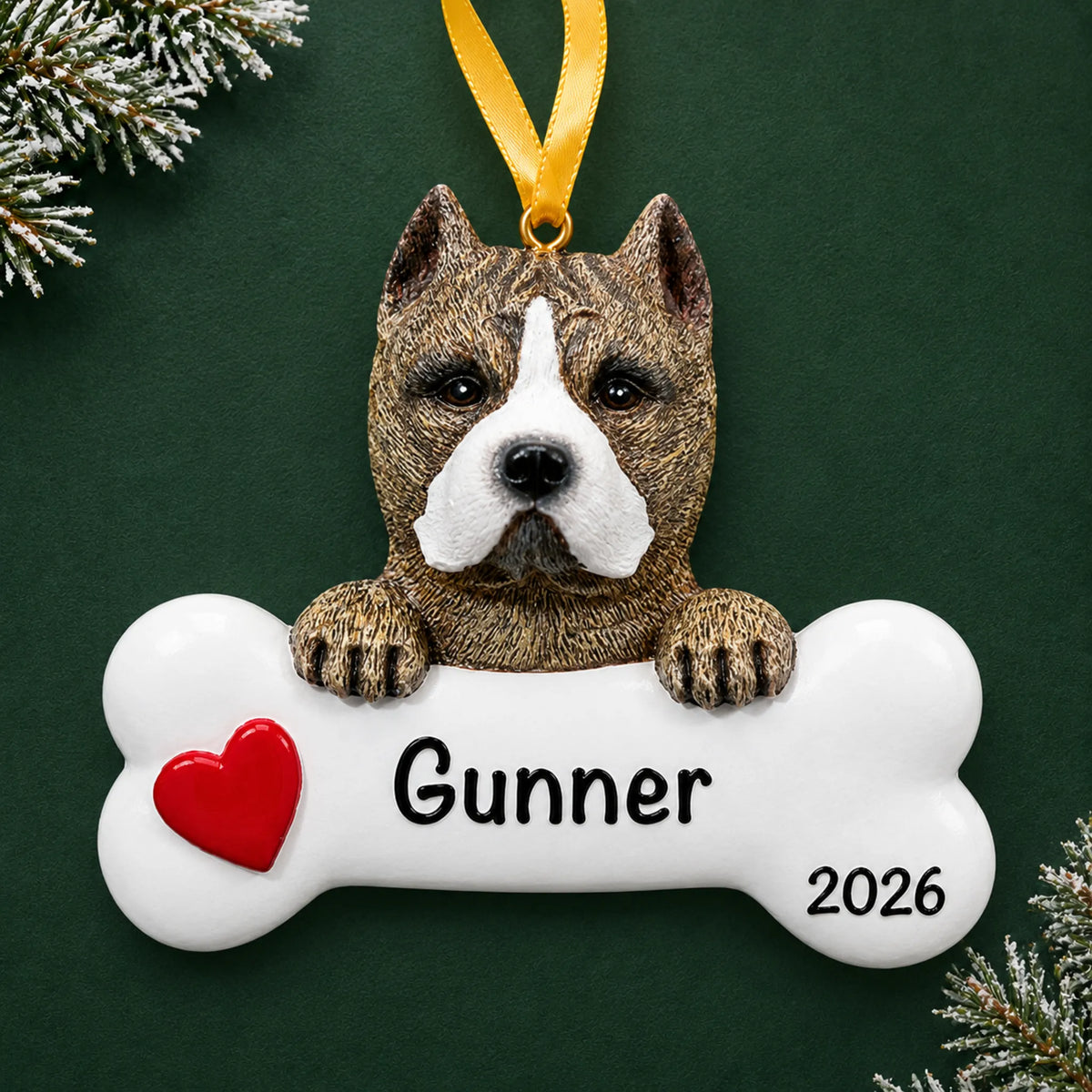 Personalized pit bull dog bone Christmas ornament, engraved with a name and year, on a green holiday backdrop