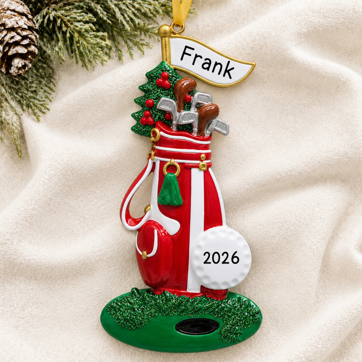 Personalized golf bag christmas ornament laid on a soft white knit blanket