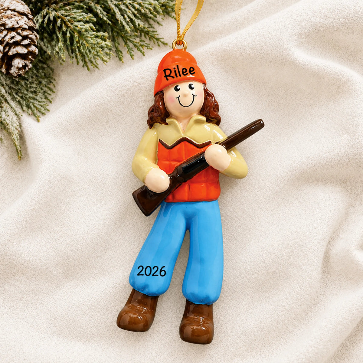 Personalized hunting girl christmas ornament laid on a soft white knit blanket