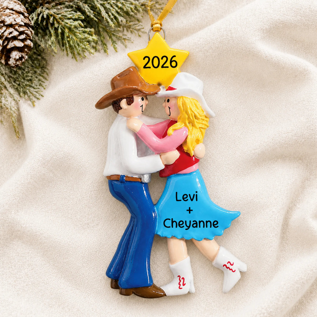 Personalized western dancing couple christmas ornament laid on a soft white knit blanket