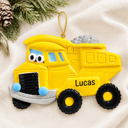 Personalized dump truck christmas ornament laid on a soft white knit blanket
