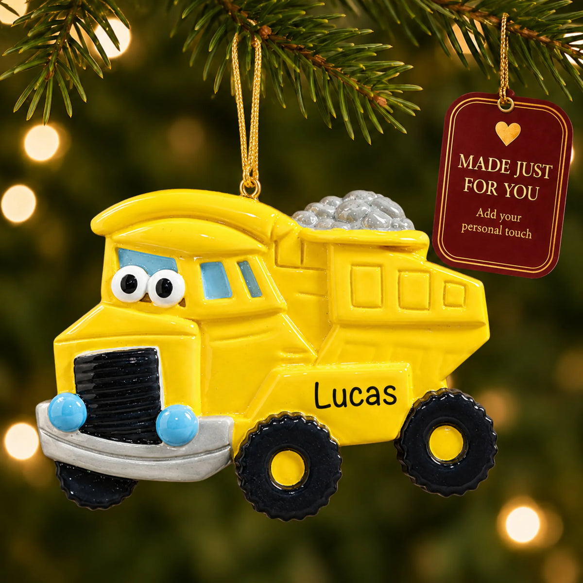 Dump truck christmas ornament hanging on a lit Christmas tree with a Made Just For You gift tag