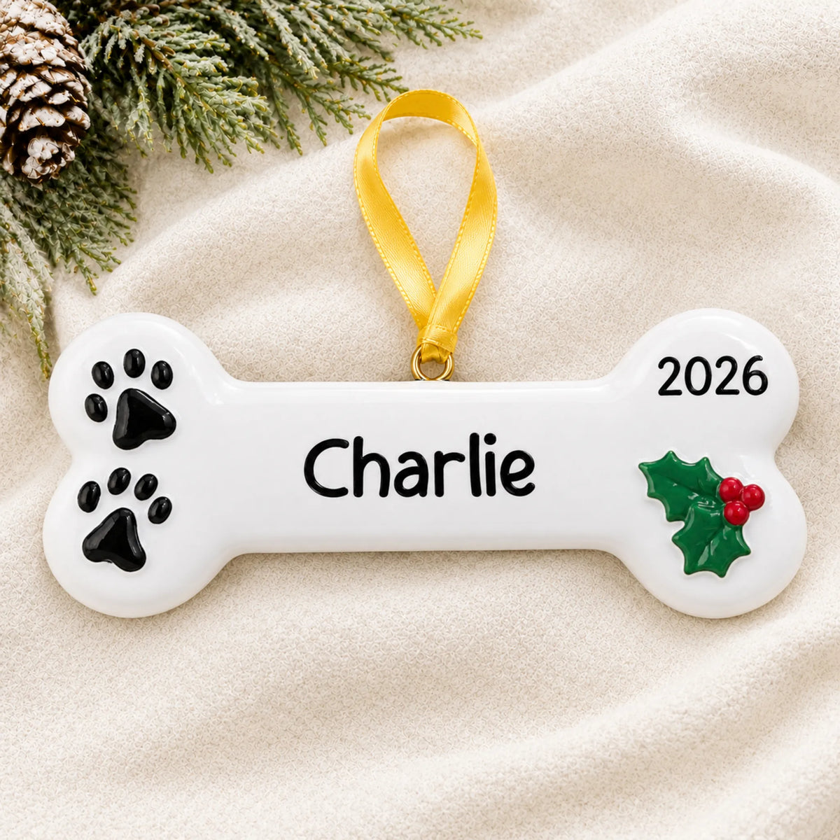 Personalized White Dog Bone christmas ornament laid on a soft white knit blanket