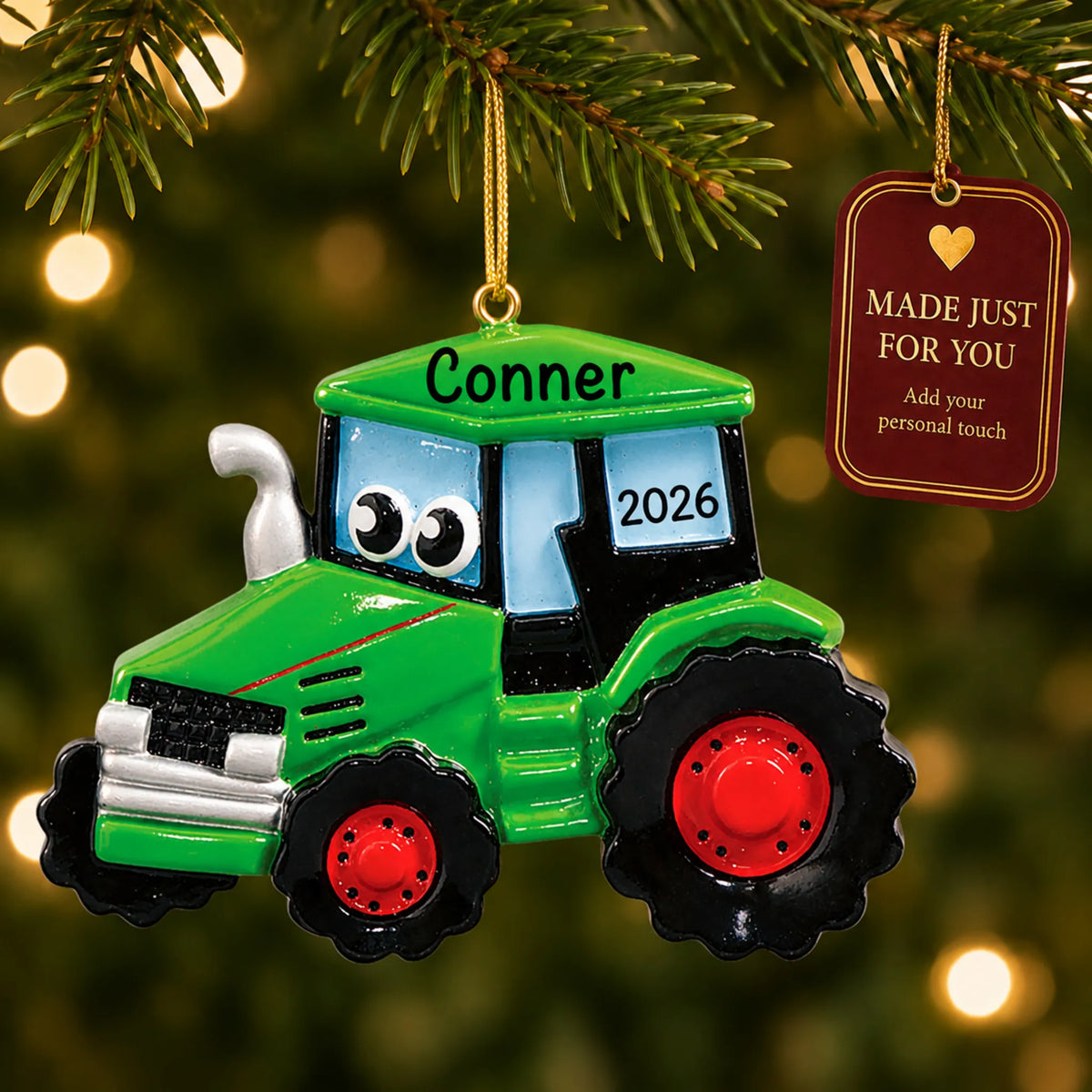 Green tractor christmas ornament hanging on a lit Christmas tree with a Made Just For You gift tag