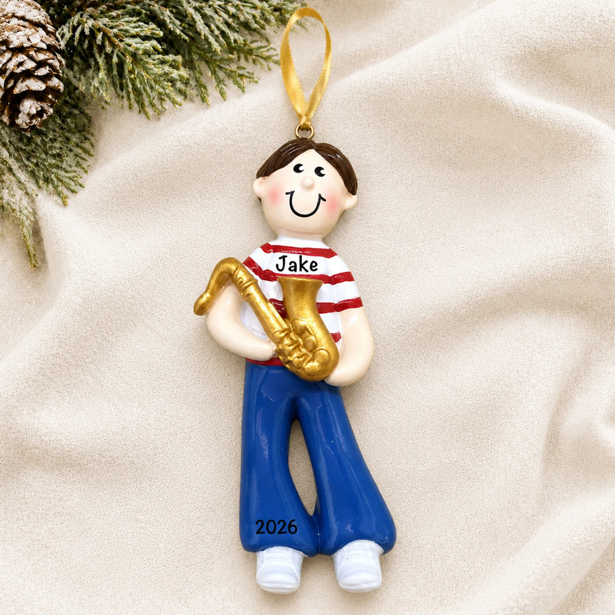 Personalized saxophone boy christmas ornament laid on a soft white knit blanket