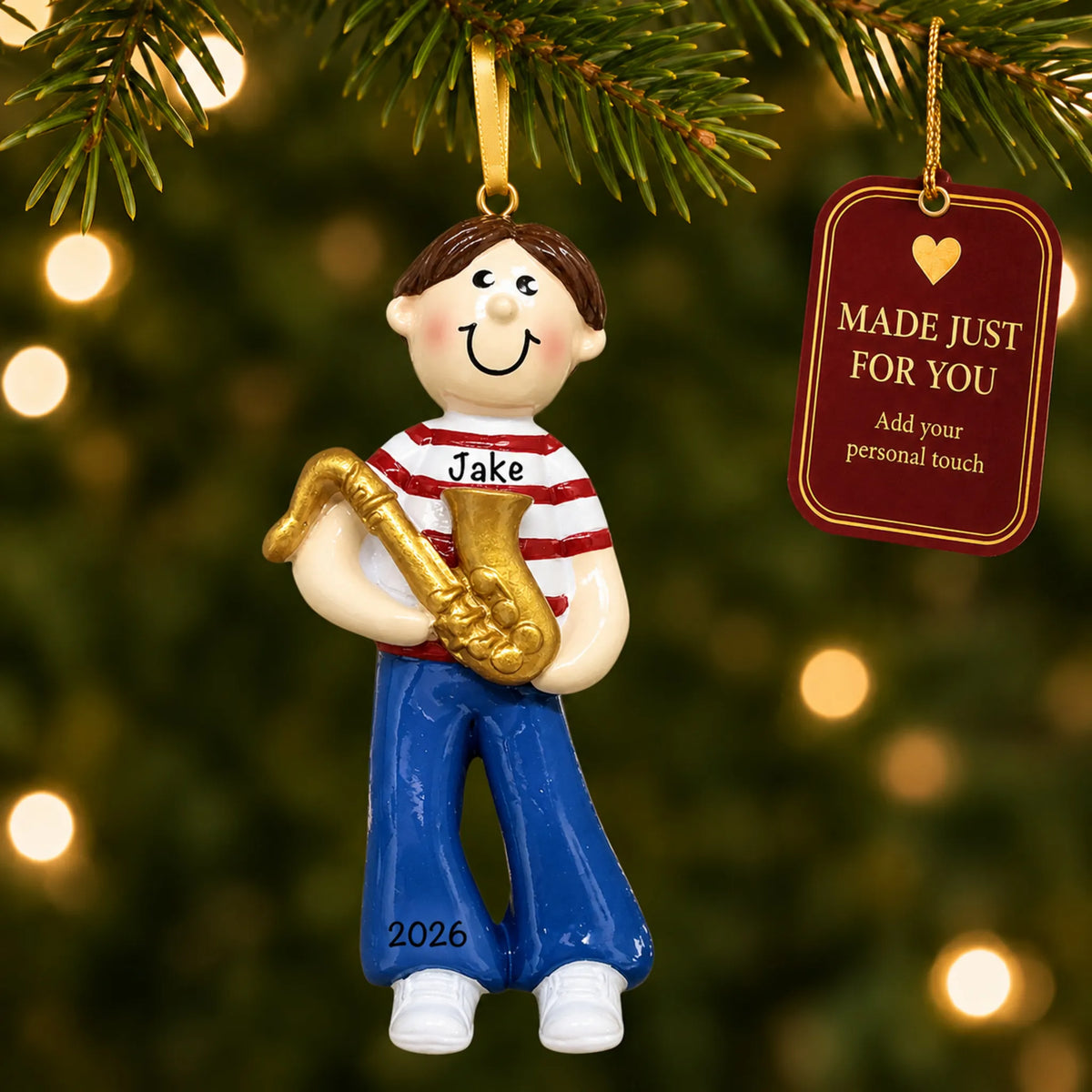 Saxophone boy christmas ornament hanging on a lit Christmas tree with a Made Just For You gift tag