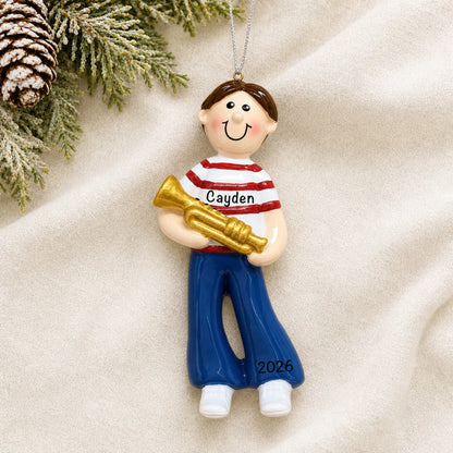 Personalized trumpet boy christmas ornament laid on a soft white knit blanket