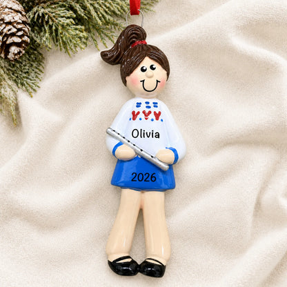 Personalized flute girl christmas ornament laid on a soft white knit blanket