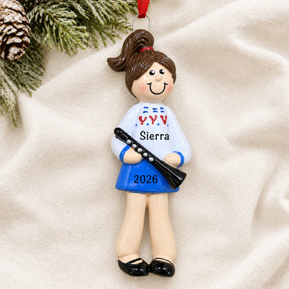 Personalized clarinet girl christmas ornament laid on a soft white knit blanket