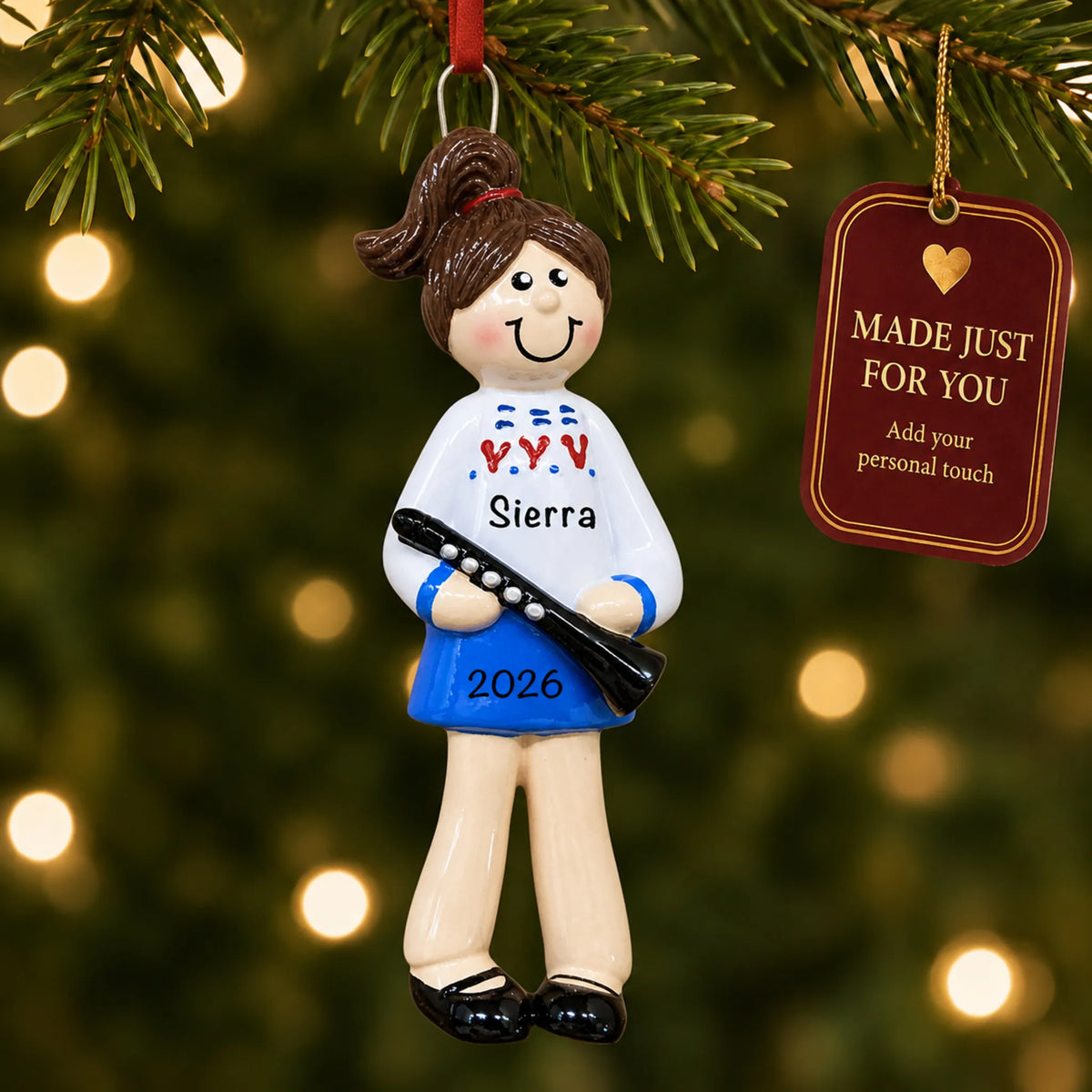 Clarinet girl christmas ornament hanging on a lit Christmas tree with a Made Just For You gift tag