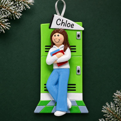 Personalized brunette school girl Christmas ornament with name and year, shown on a green holiday background