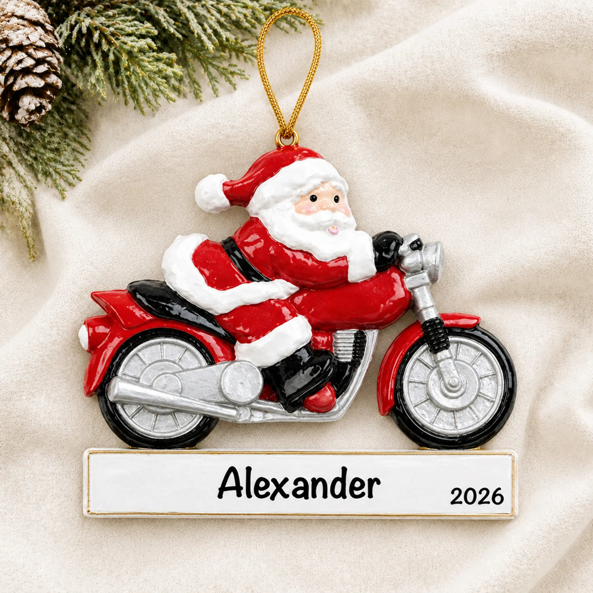 Personalized Santa Motorcycle christmas ornament laid on a soft white knit blanket