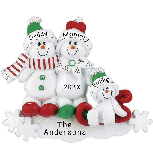 Personalized Christmas ornament featuring a snowman family of three (two adults and one child on a red sled) ready for custom name and year engraving on the snow base.