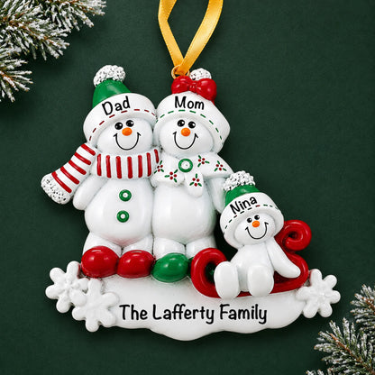 Personalized snowman sled family of 3 christmas ornament on a dark green pine background