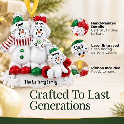 Hand-painted details and laser engraved personalization on the snowman sled family of 3 christmas ornament, ribbon included