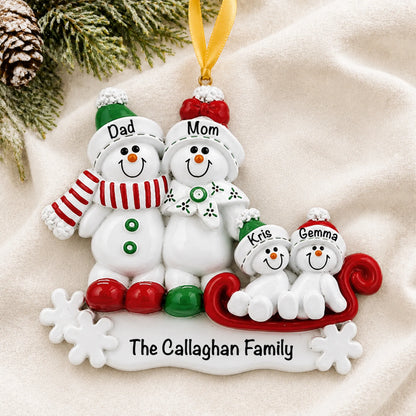 Personalized snowman sled family of 4 christmas ornament laid on a soft white knit blanket