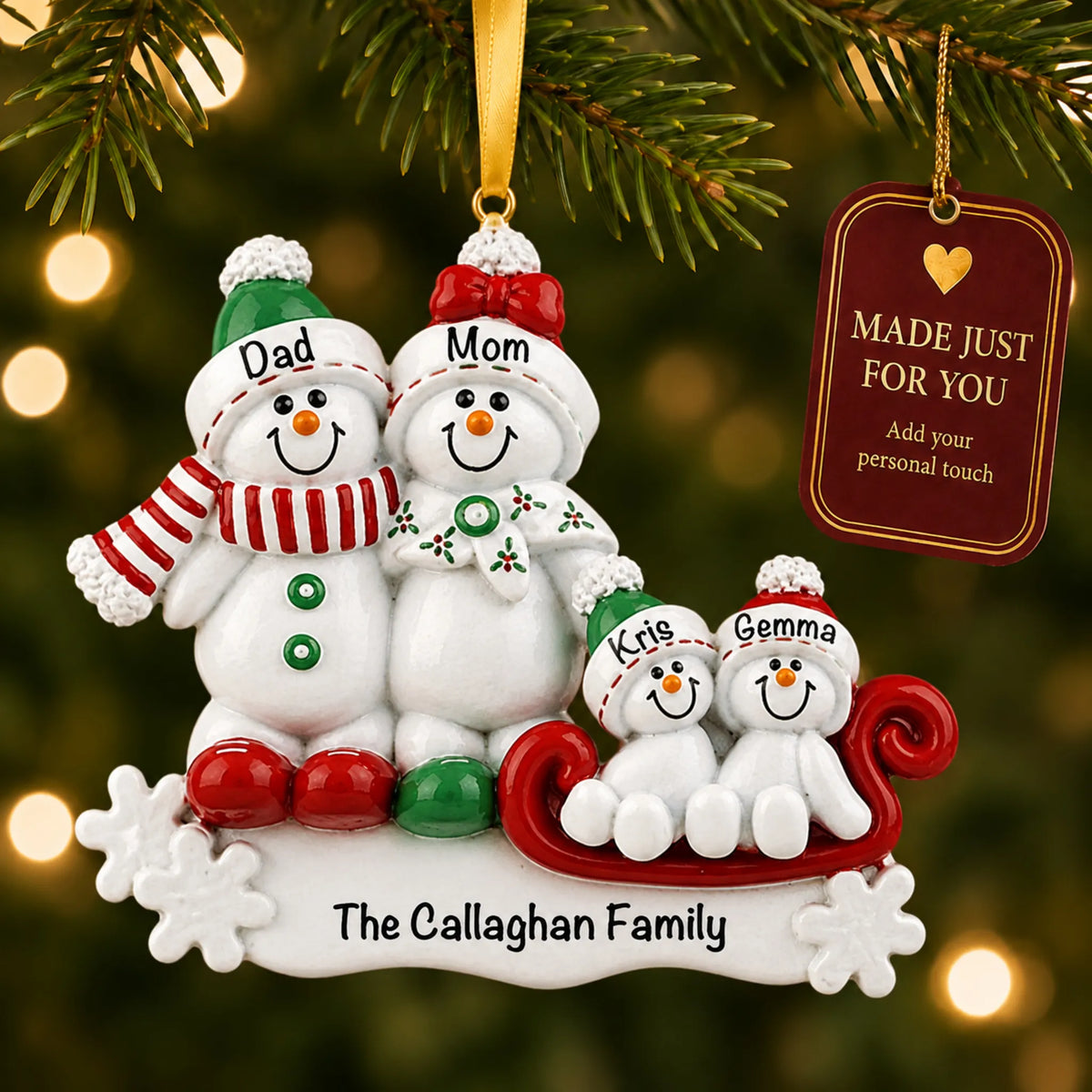Snowman sled family of 4 christmas ornament hanging on a lit Christmas tree with a Made Just For You gift tag