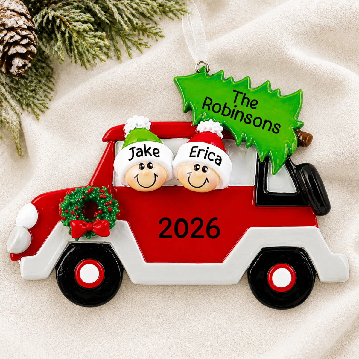 Personalized christmas tree car couple ornament laid on a soft white knit blanket