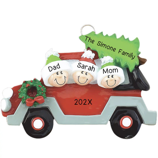Personalized Christmas ornament featuring a family of three (two adults, one child) in a red car with a Christmas tree on the roof and a wreath on the grille, ready for custom name and year engraving.
