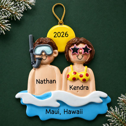 Personalized beach & sea couple christmas ornament, a snorkeling beach couple on a wave, on a dark green pine background