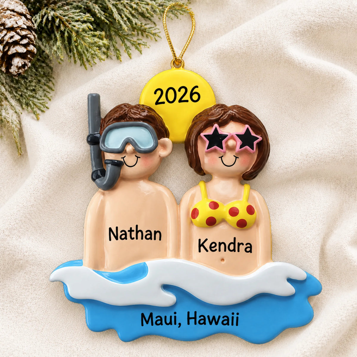 Personalized beach & sea couple christmas ornament laid on a soft white knit blanket