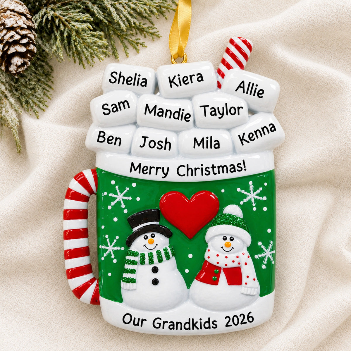 Personalized cocoa mug family Christmas ornament, marshmallow names above two snowmen on a green mug
