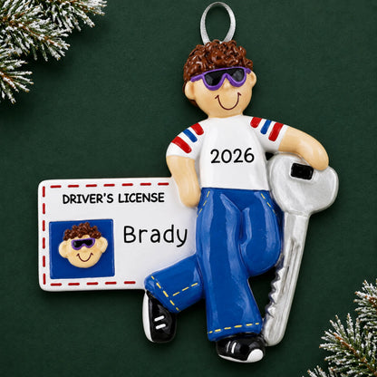 Personalized new driver's license brunette boy christmas ornament on a dark green pine background