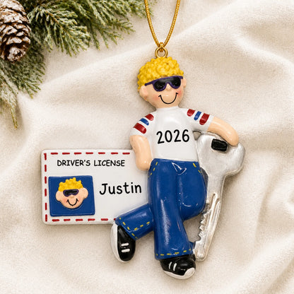 Personalized new driver's license blonde boy christmas ornament laid on a soft white knit blanket