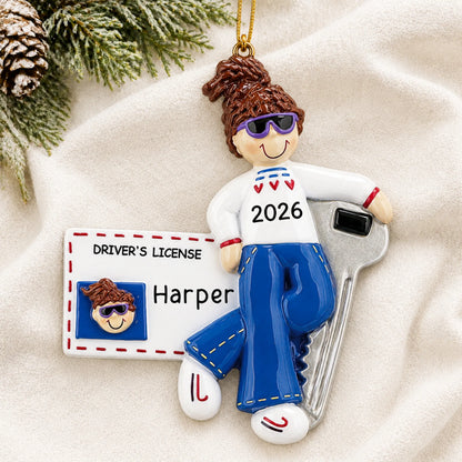 Personalized New Driver Brunette Girl christmas ornament laid on a soft white knit blanket