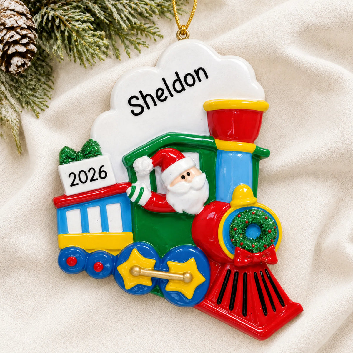 Personalized Santa Train christmas ornament laid on a soft white knit blanket
