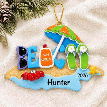 Personalized beach bum christmas ornament laid on a soft white knit blanket