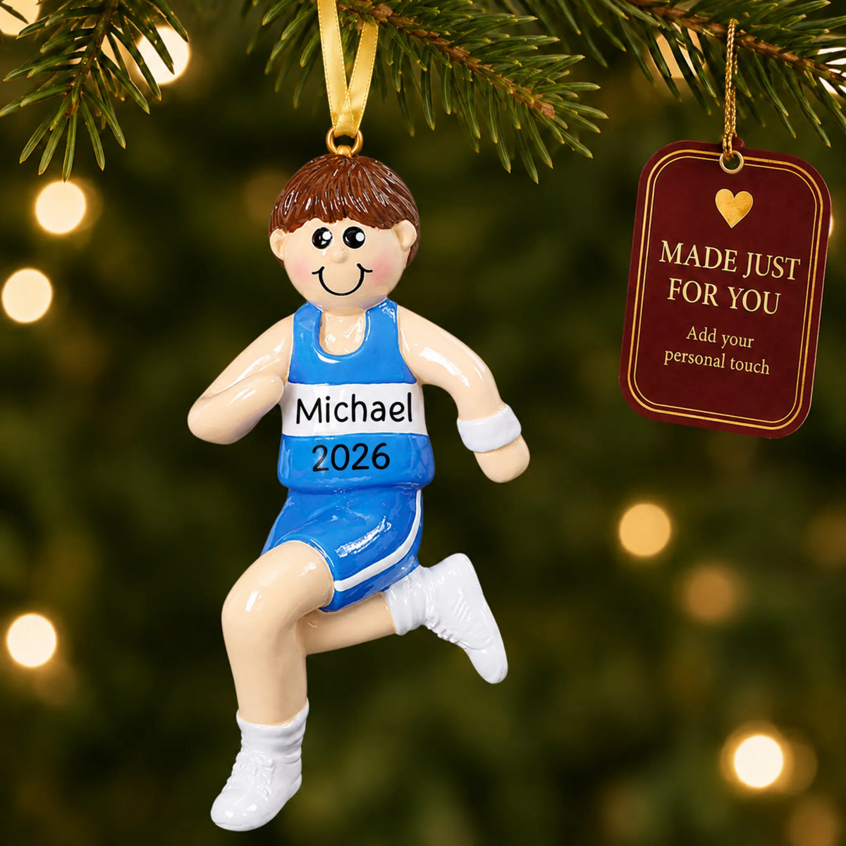 Track runner boy christmas ornament hanging on a lit Christmas tree with a Made Just For You gift tag