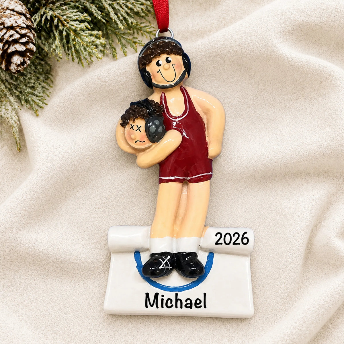 Personalized male wrestler in a red singlet christmas ornament laid on a soft white knit blanket