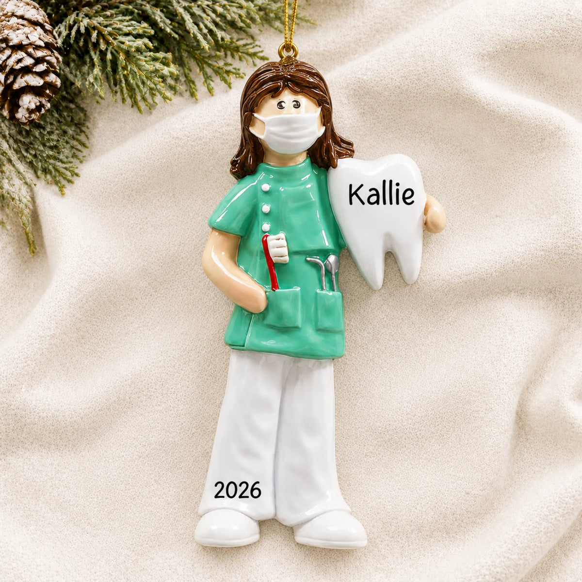 Personalized female dental professional christmas ornament laid on a soft white knit blanket