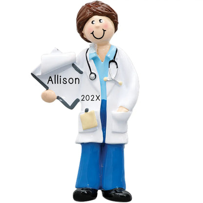 A personalized ornament featuring a stylized doctor character in blue scrubs and a white coat, holding a clipboard with 'Allison Year' written on it, and a stethoscope. The doctor is smiling and has a medical theme throughout.