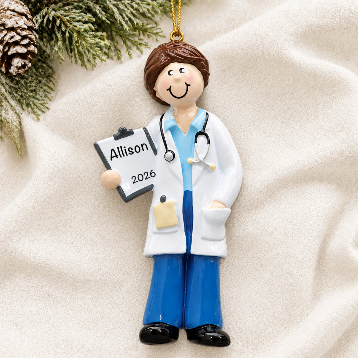 Personalized doctor girl christmas ornament laid on a soft white knit blanket
