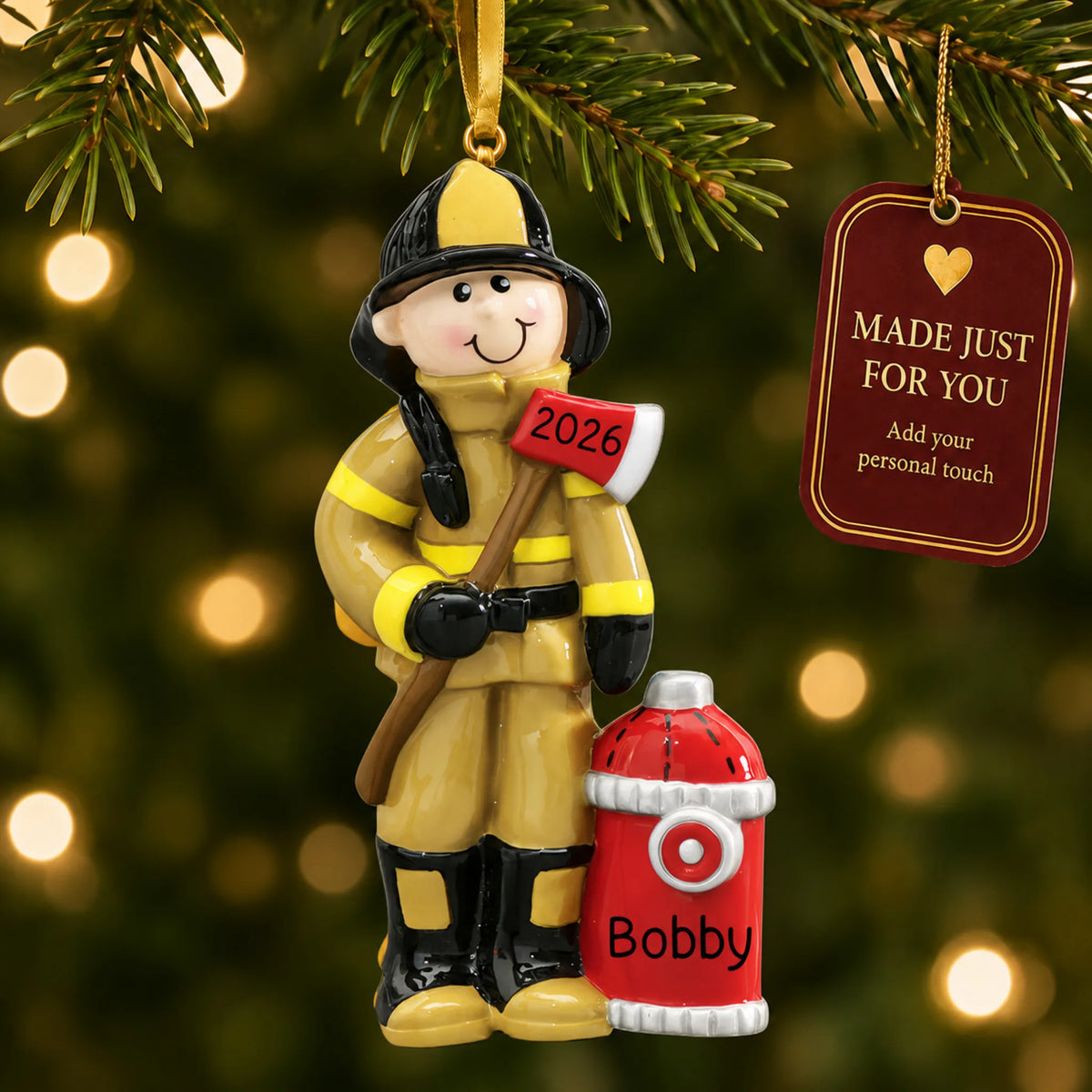 Firefighter christmas ornament hanging on a lit Christmas tree with a Made Just For You gift tag