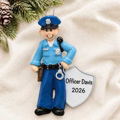 Personalized police officer christmas ornament laid on a soft white knit blanket