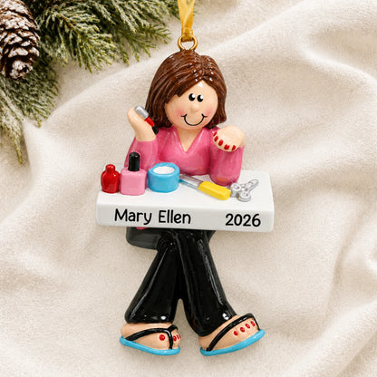 Personalized nail tech christmas ornament laid on a soft white knit blanket