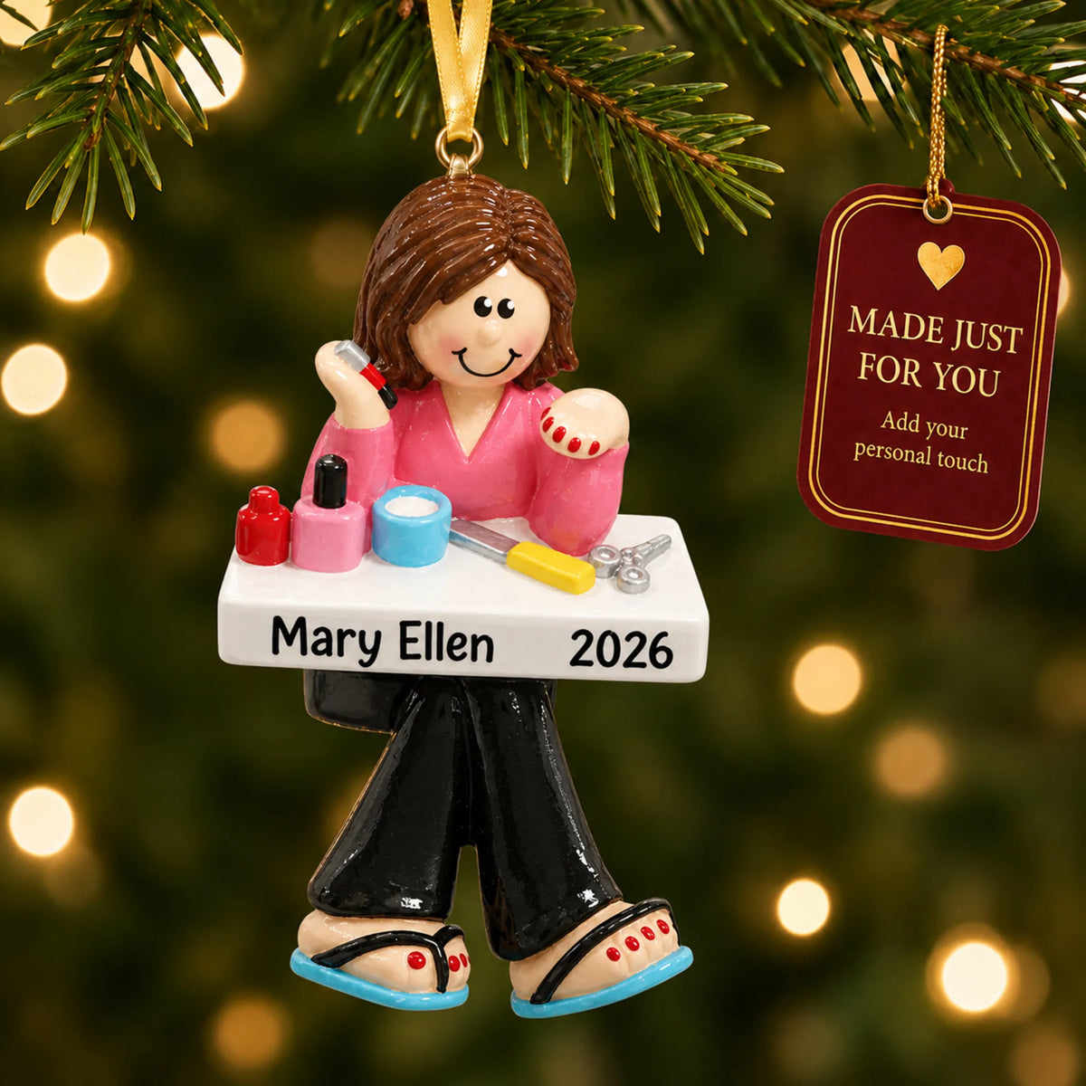 Nail tech christmas ornament hanging on a lit Christmas tree with a Made Just For You gift tag
