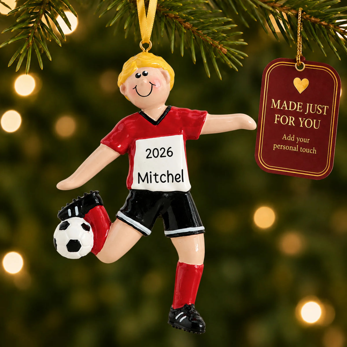 Blonde soccer guy christmas ornament hanging on a lit Christmas tree with a Made Just For You gift tag