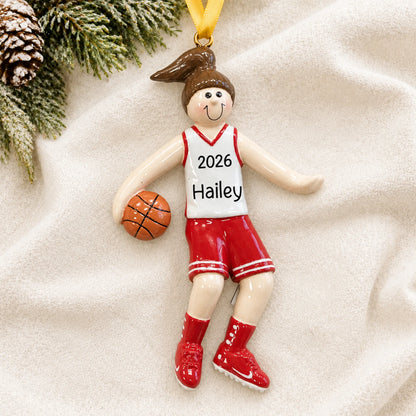 Personalized basketball girl christmas ornament laid on a soft white knit blanket